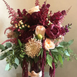 A Vibrant Bouquet Of Burgundy Flowers With Peach Accents