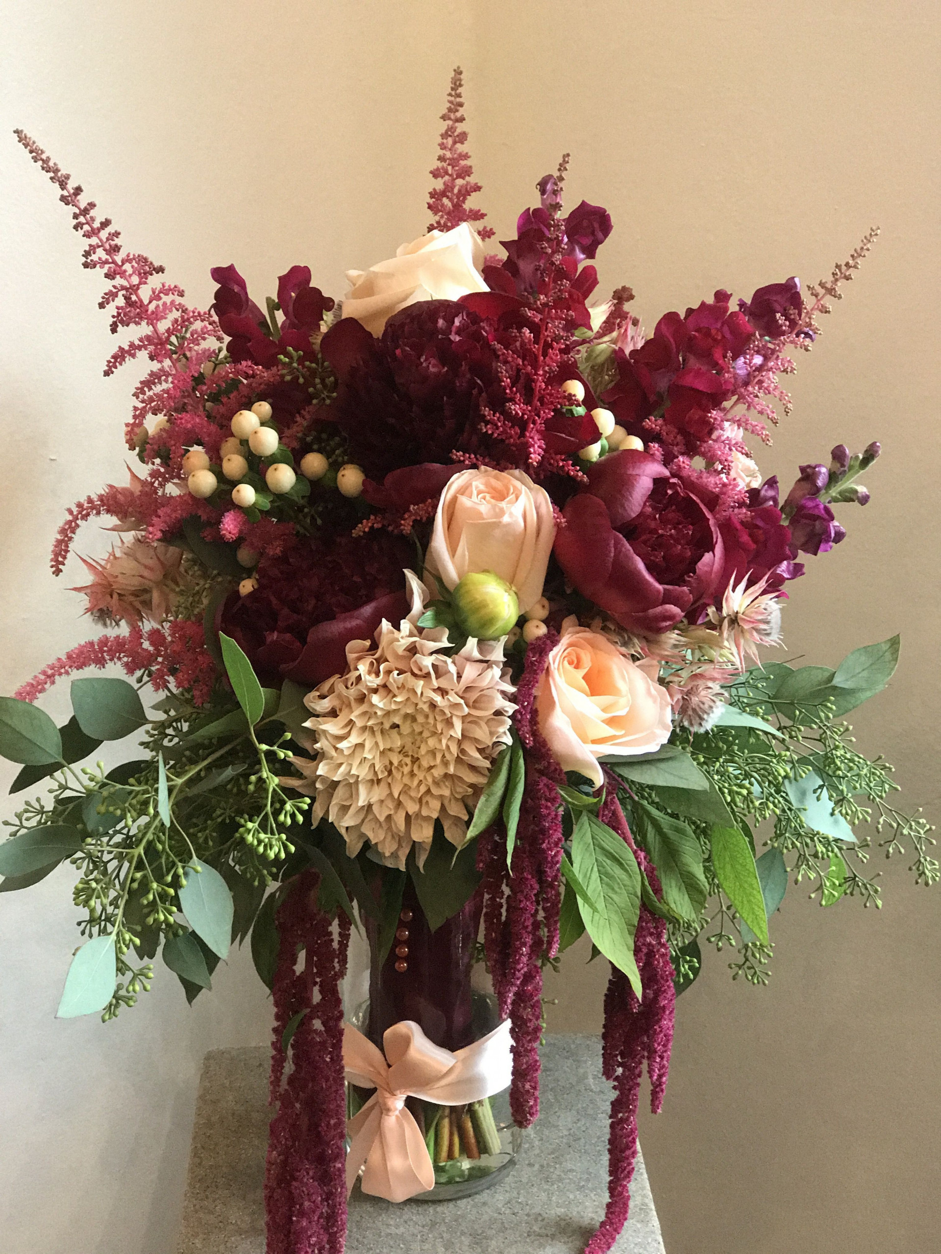 A Vibrant Bouquet Of Burgundy Flowers With Peach Accents 